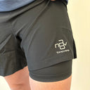 Trinovate Elite Run Short, schwarz, Detailansicht am männlichen Modell